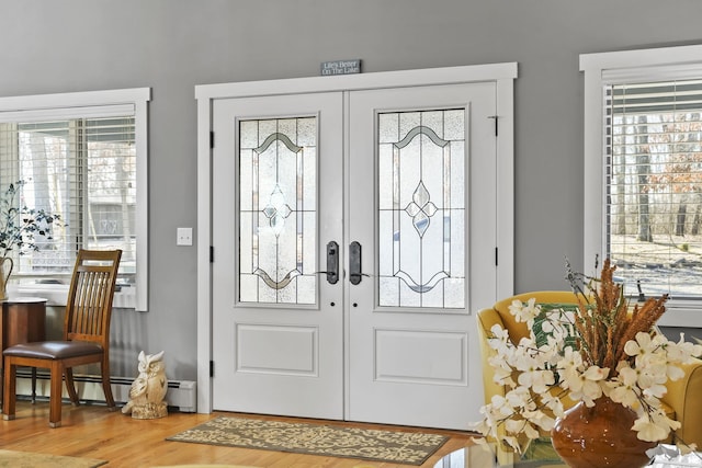 entrance foyer featuring wood finished floors, french doors, and baseboard heating