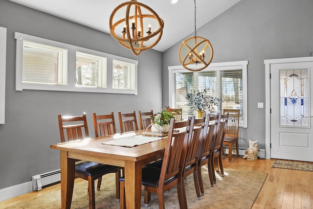 dining area featuring an inviting chandelier, light wood-style flooring, lofted ceiling, and a baseboard radiator