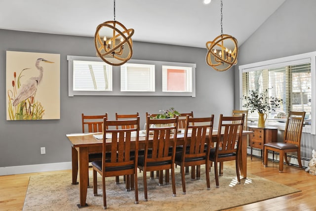 dining room featuring baseboards, vaulted ceiling, wood finished floors, a notable chandelier, and a baseboard radiator