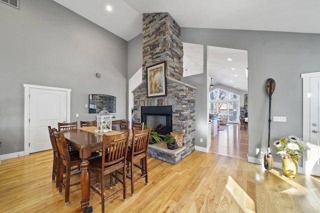 dining room featuring visible vents, baseboards, light wood-style flooring, and a fireplace