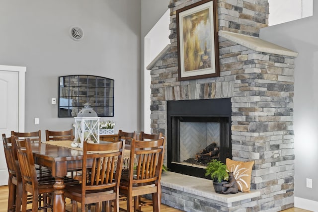 dining area featuring visible vents, wood finished floors, and a fireplace