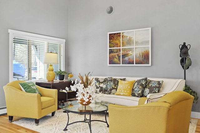 living area with visible vents and wood finished floors