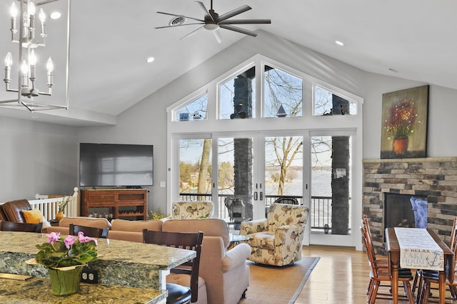 living area featuring an inviting chandelier, recessed lighting, a fireplace, and light wood-style floors