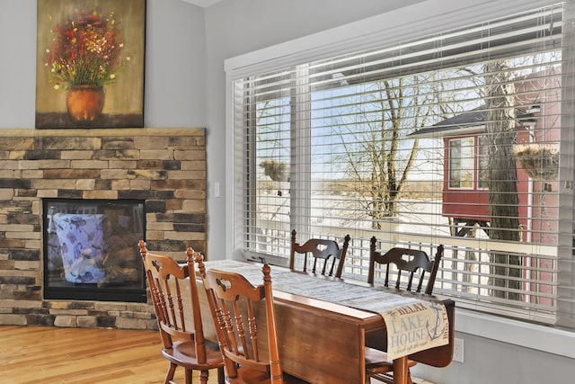 dining room with a glass covered fireplace and wood finished floors