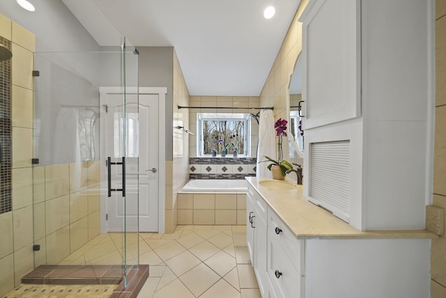 full bathroom with tile patterned flooring, a shower stall, a relaxing tiled tub, and vanity