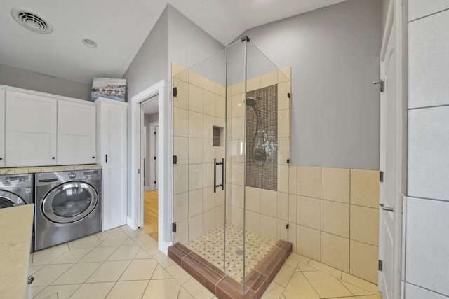 full bathroom featuring tile patterned flooring, visible vents, a shower stall, washing machine and dryer, and tile walls