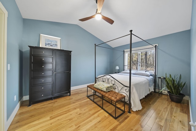 bedroom with a ceiling fan, baseboards, a baseboard radiator, lofted ceiling, and light wood-style flooring