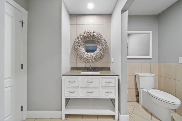 bathroom featuring tile patterned floors, toilet, tile walls, and vanity