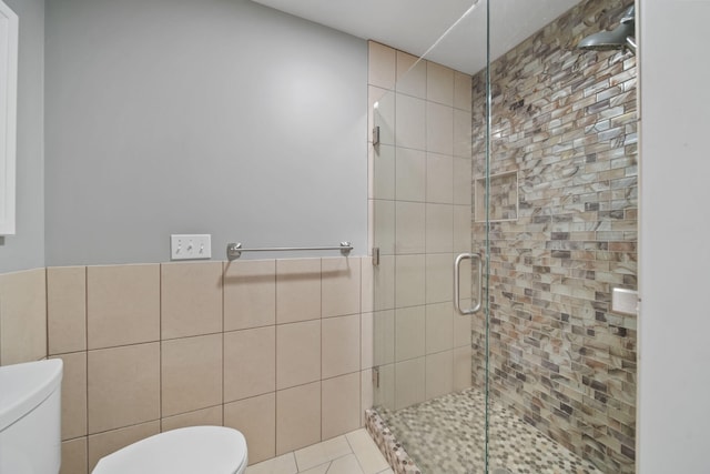 full bath with tile walls, toilet, and a stall shower