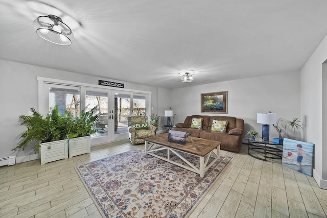 living area with wood finished floors, french doors, and baseboards