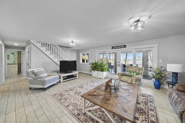 living room with wood finished floors, stairway, french doors, a baseboard radiator, and baseboards