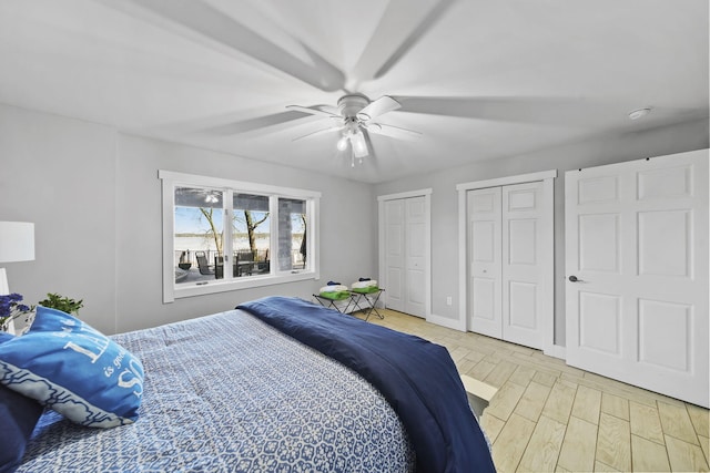 bedroom featuring baseboards, multiple closets, light wood-style floors, and a ceiling fan