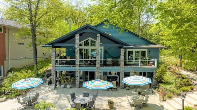 back of property with a wooden deck and a patio area