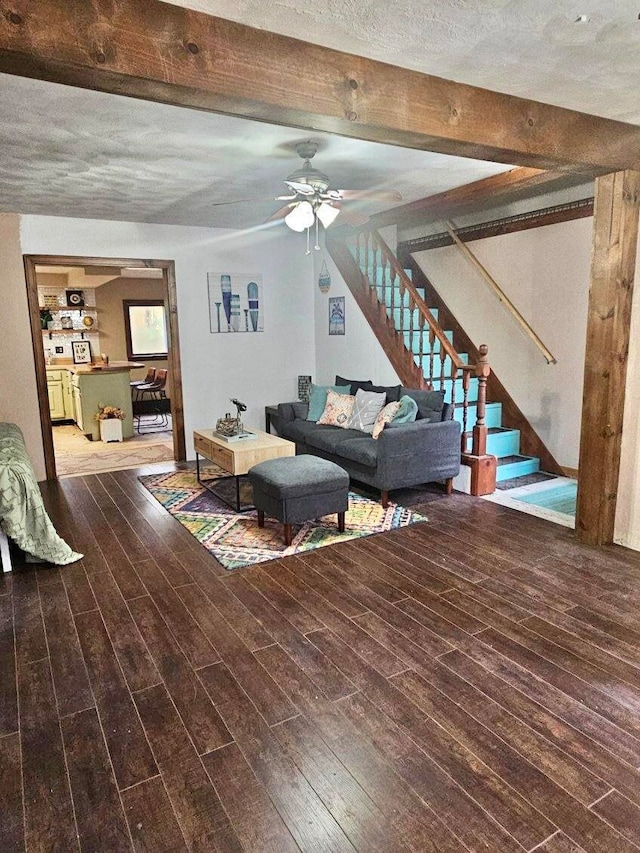 unfurnished living room with ceiling fan, beam ceiling, and wood-type flooring