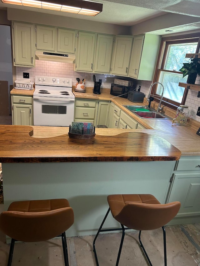 kitchen featuring wood counters, a breakfast bar, sink, electric range, and green cabinetry