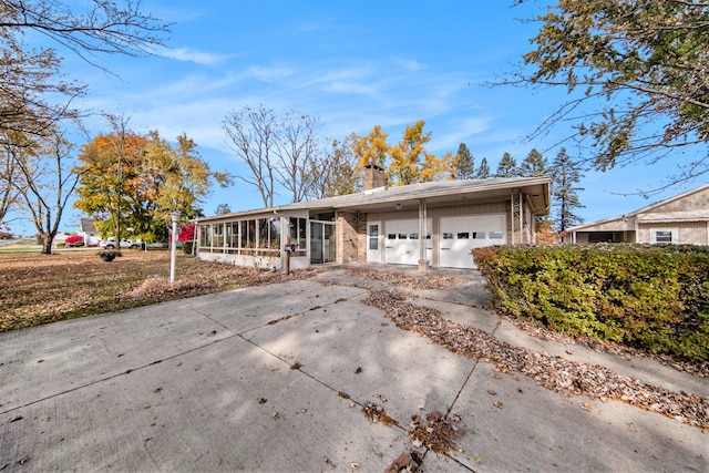 single story home with a garage and a sunroom