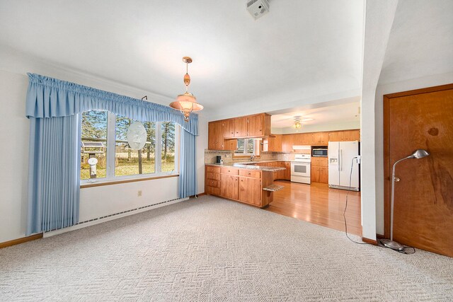 kitchen with kitchen peninsula, stove, light carpet, pendant lighting, and white fridge with ice dispenser