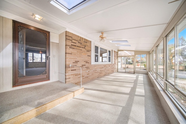 unfurnished sunroom featuring ceiling fan and lofted ceiling with skylight