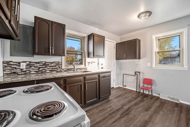 kitchen with backsplash, dark brown cabinetry, white range oven, dark wood-type flooring, and sink