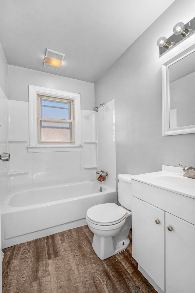 full bathroom with hardwood / wood-style floors, vanity,  shower combination, and toilet