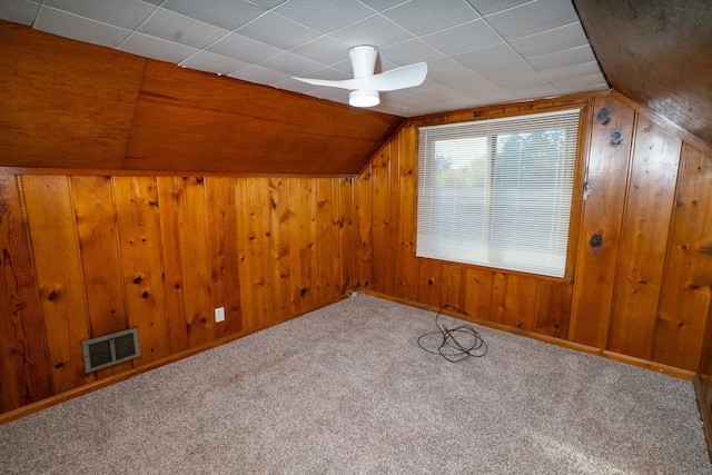 bonus room featuring carpet flooring, lofted ceiling, and wooden walls