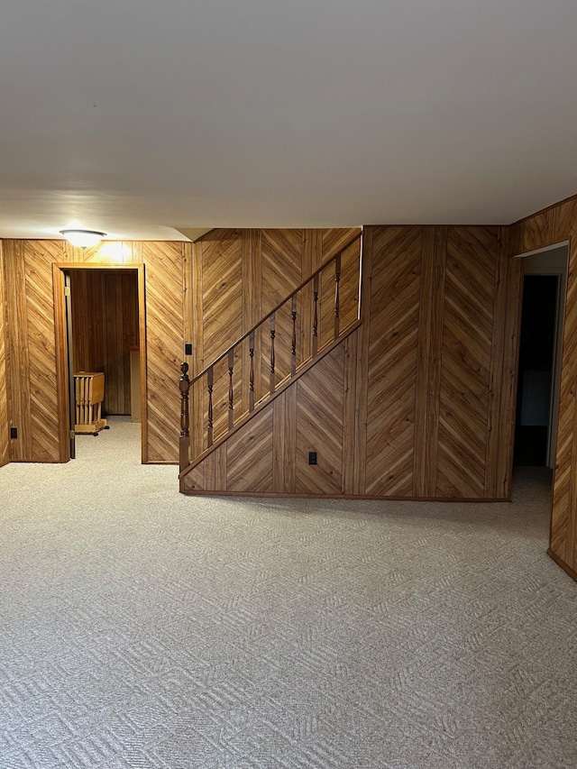 basement featuring carpet and wood walls