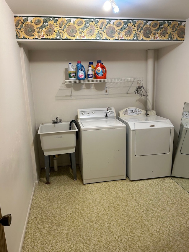 laundry area with separate washer and dryer and sink