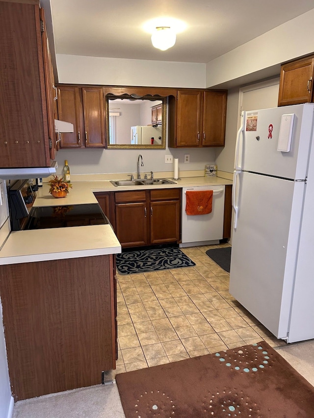 kitchen with light tile patterned floors, white appliances, and sink