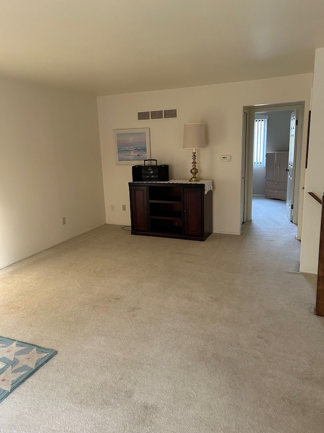 unfurnished living room featuring light colored carpet