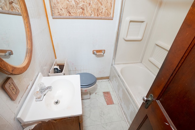 bathroom featuring vanity, a tub to relax in, and tile walls