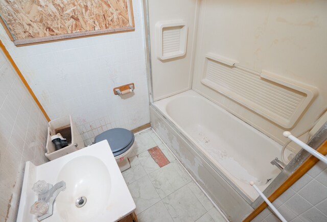 16226 Mark Twain St, Detroit, MI 48235 - bathroom with toilet, marble look tiles, vanity, tile walls, and tub / shower combination