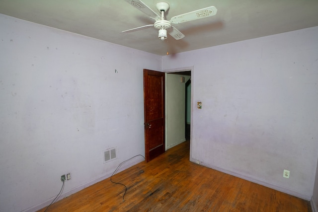 spare room with dark hardwood / wood-style flooring and ceiling fan