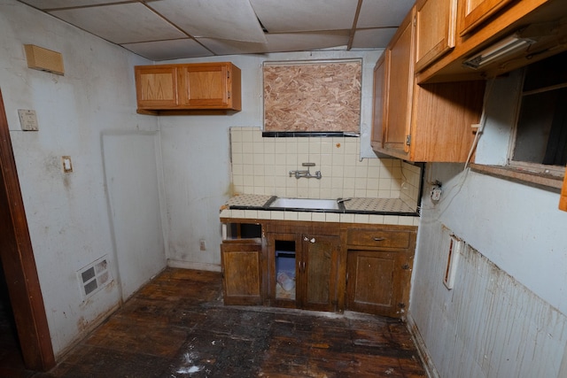 kitchen with backsplash, tile countertops, a paneled ceiling, and sink