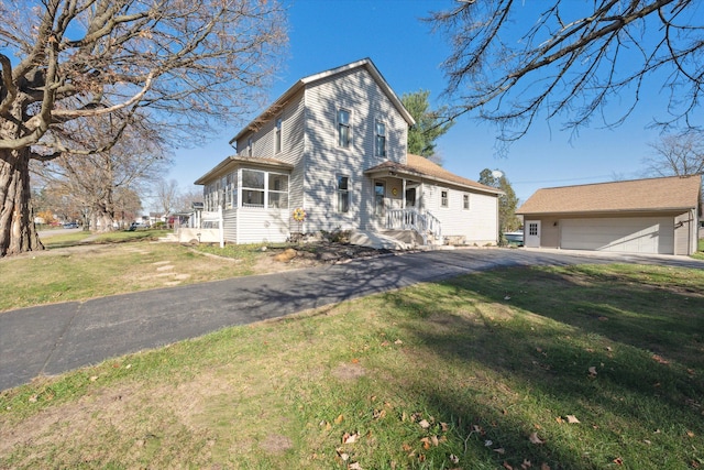 view of front of home with a garage, an outbuilding, and a front yard