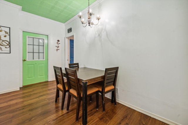 dining room featuring dark hardwood / wood-style floors, an inviting chandelier, and ornamental molding