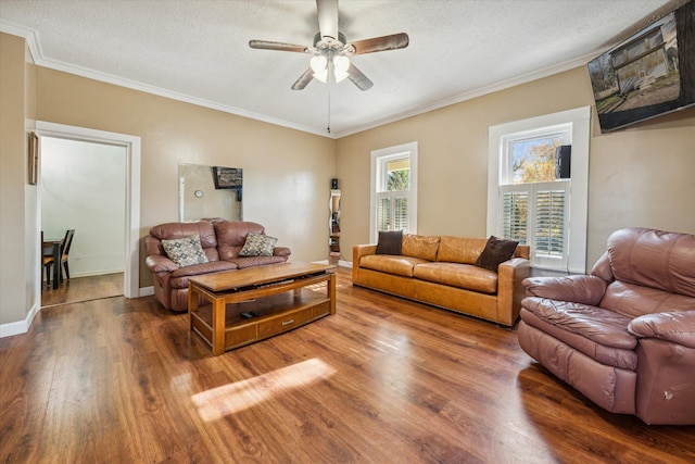 living room with a textured ceiling, hardwood / wood-style flooring, ceiling fan, and ornamental molding