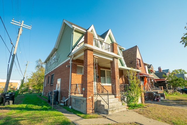 view of front of property with a balcony and a front yard