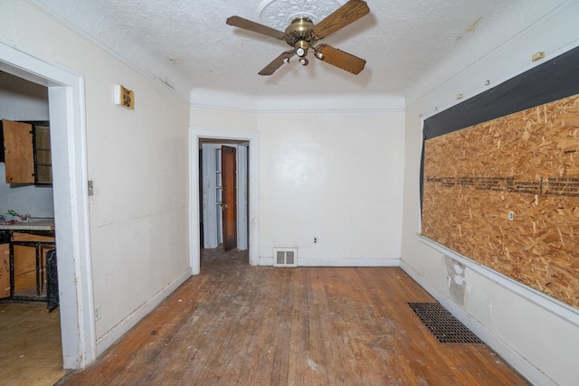 empty room with dark hardwood / wood-style floors, ceiling fan, and a textured ceiling