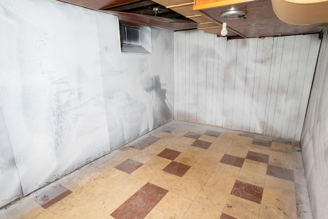 basement featuring wood walls