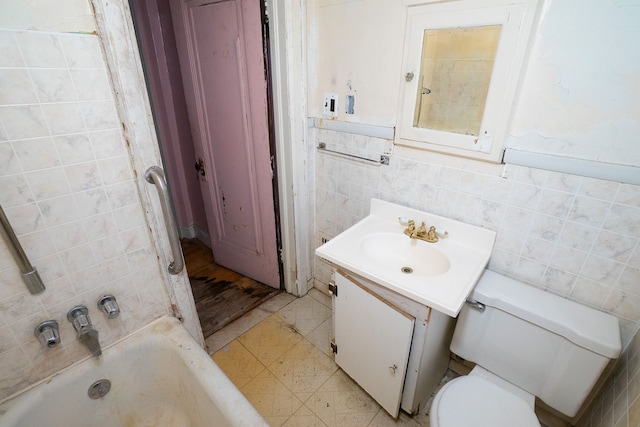 bathroom featuring vanity, toilet, tile walls, and a tub