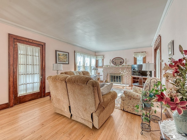 living room featuring light wood-type flooring, crown molding, and a brick fireplace