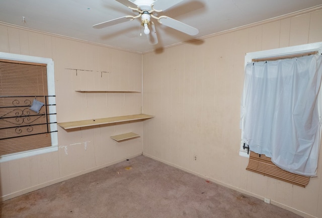 spare room with ceiling fan, light colored carpet, and ornamental molding