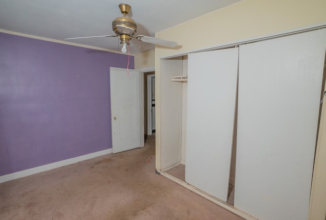 unfurnished bedroom featuring crown molding, ceiling fan, a closet, and light colored carpet