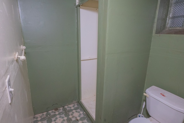 bathroom featuring walk in shower and toilet