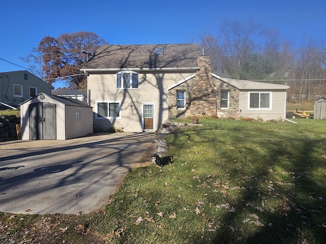 back of house with a yard and a storage unit