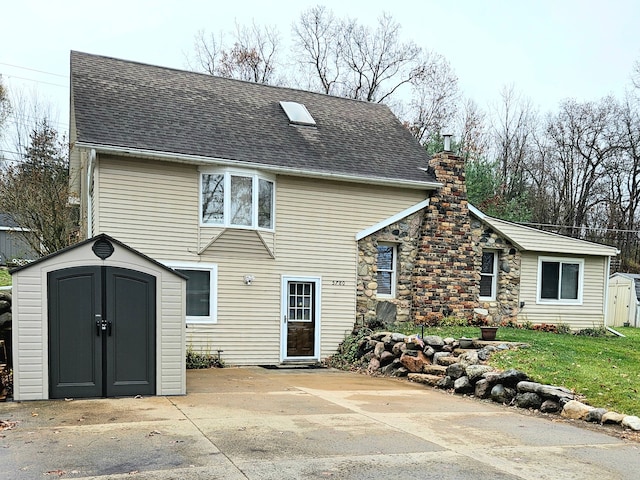 rear view of property featuring a patio area and a storage unit