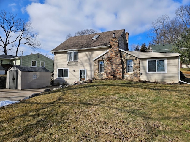 back of property featuring a chimney, a storage unit, a lawn, stone siding, and an outdoor structure