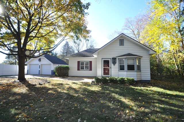 single story home featuring a front yard, an outdoor structure, and a garage