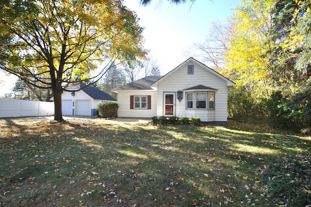 ranch-style home with a front yard, an outdoor structure, and a garage