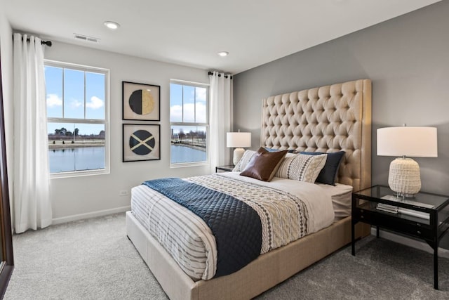 bedroom featuring baseboards, visible vents, a water view, carpet floors, and recessed lighting